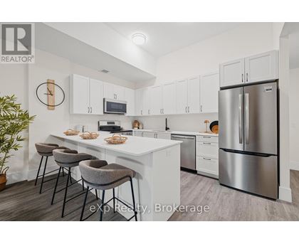 A kitchen with white cabinets and a stainless steel refrigerator.