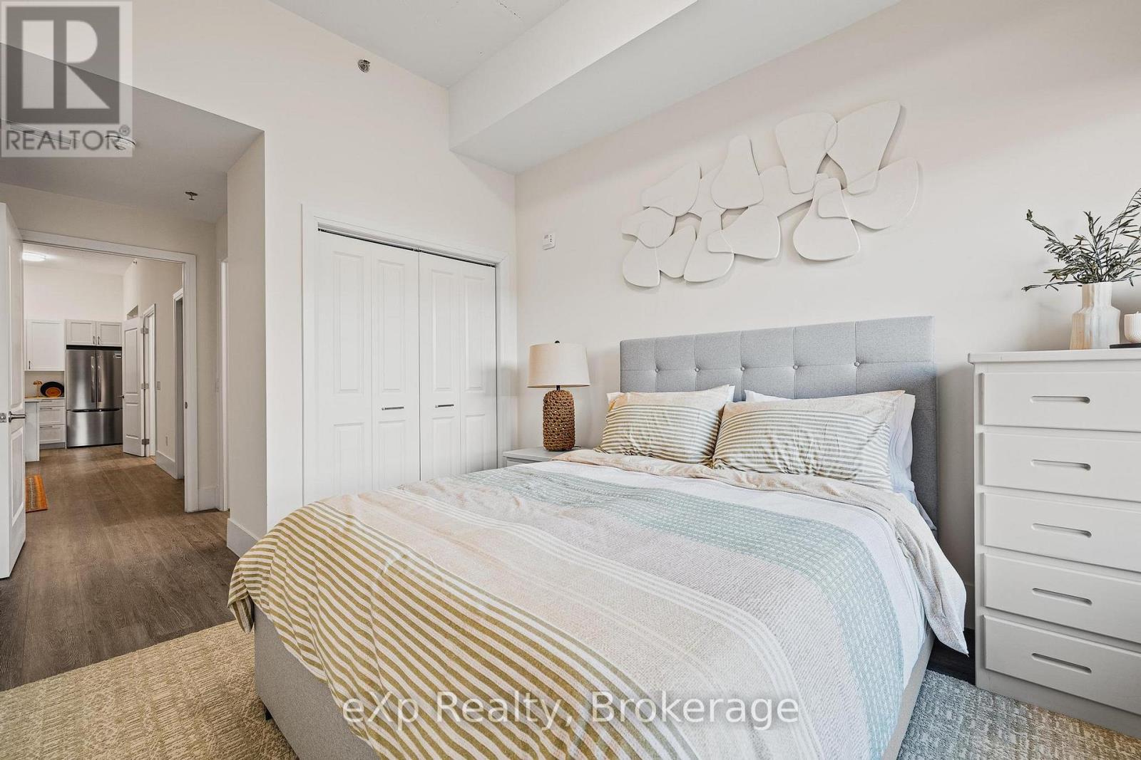 A bedroom with a large bed and a white dresser.