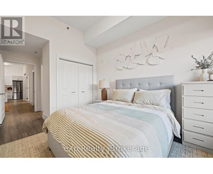 A bedroom with a large bed and a white dresser.