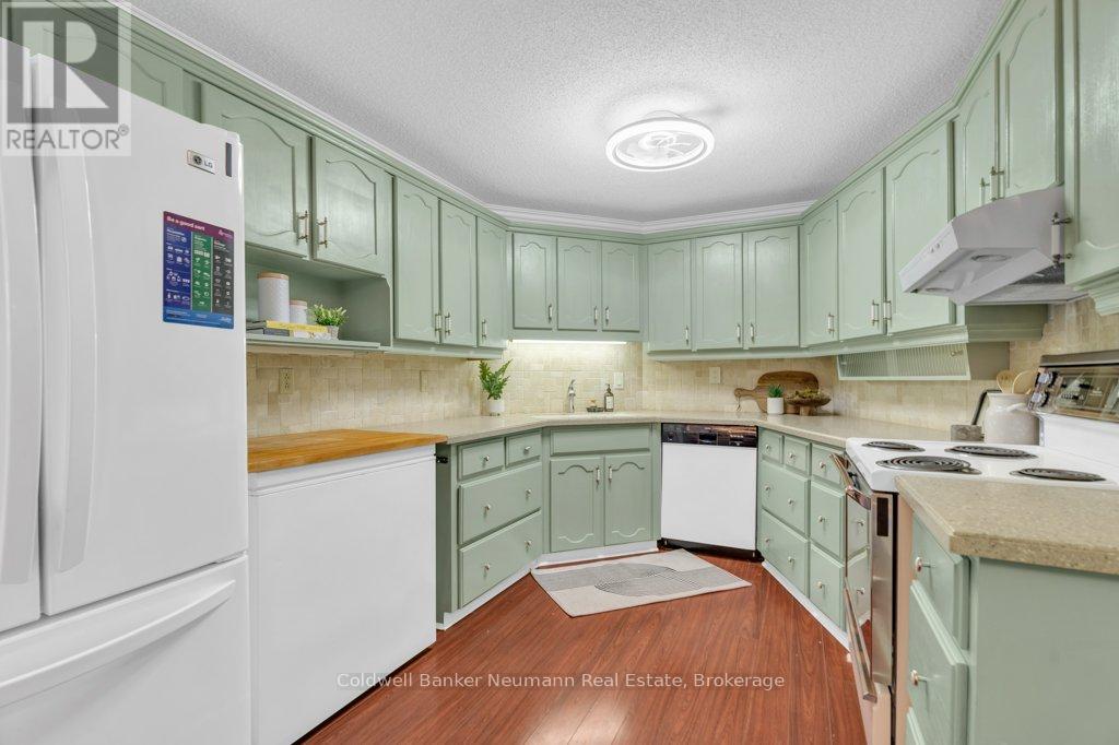 A kitchen with green cabinets and a white refrigerator.