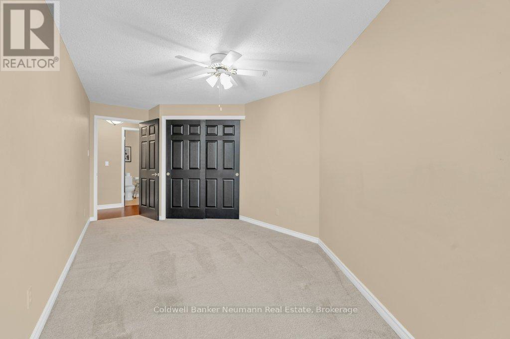 A bedroom with a ceiling fan and a large closet with doors.