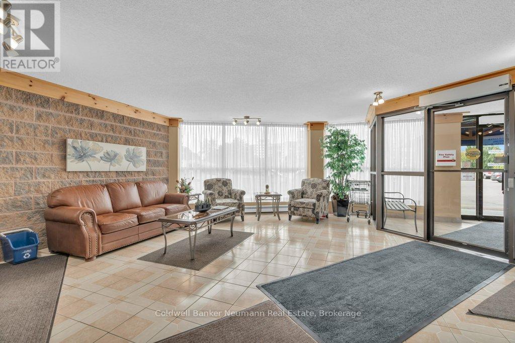 A living room with a brown leather couch and a glass table.