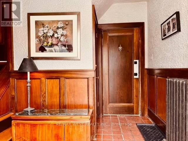 A hallway with a wooden door and a framed picture on the wall.