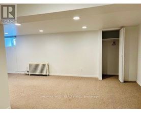 A room with a carpeted floor and a heater.