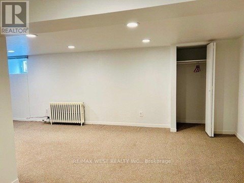 A room with a carpeted floor and a heater.