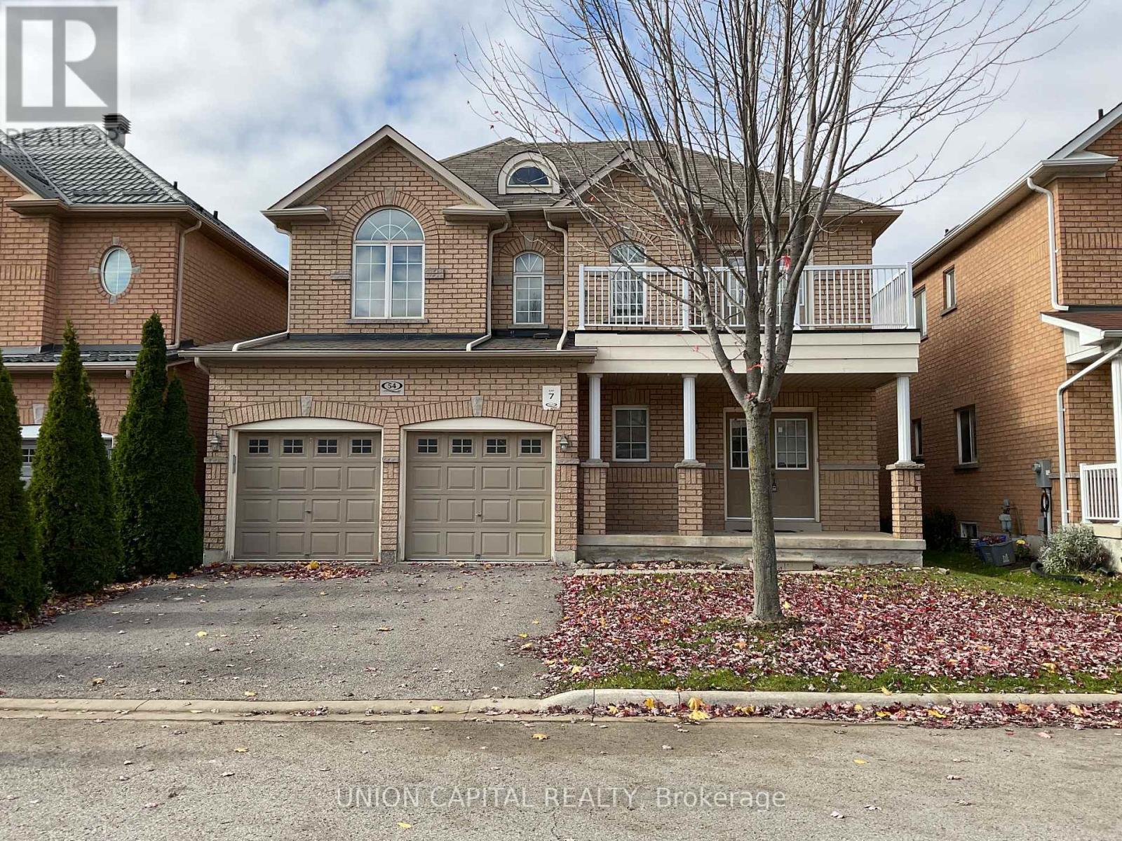 A brick house with a tree in front and a sign that says Union Capital Realty Brokerage.