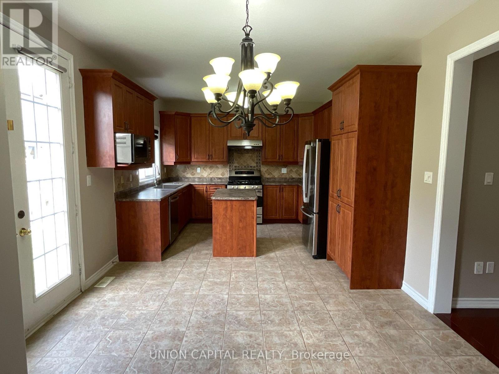 A kitchen with wooden cabinets and a tiled floor.