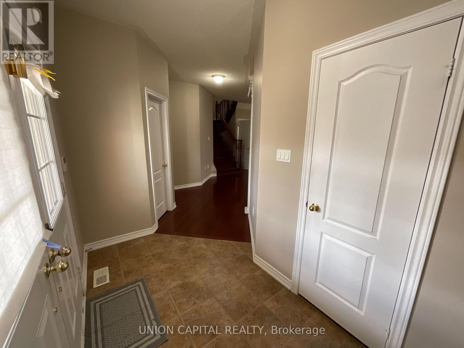 A hallway with a white door and a brown floor.