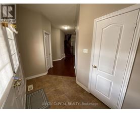 A hallway with a white door and a brown floor.