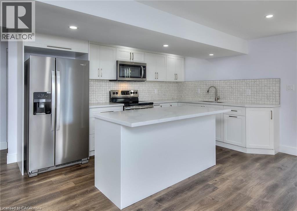 A modern kitchen with a stainless steel refrigerator and white countertops.