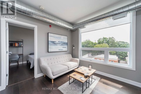 A living room with a white sofa, a coffee table, and a painting on the wall.