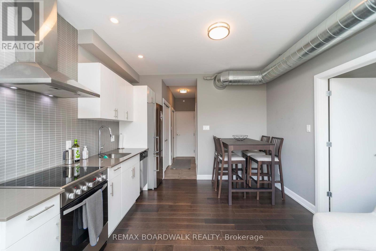 A modern kitchen with white cabinets and a dining table.
