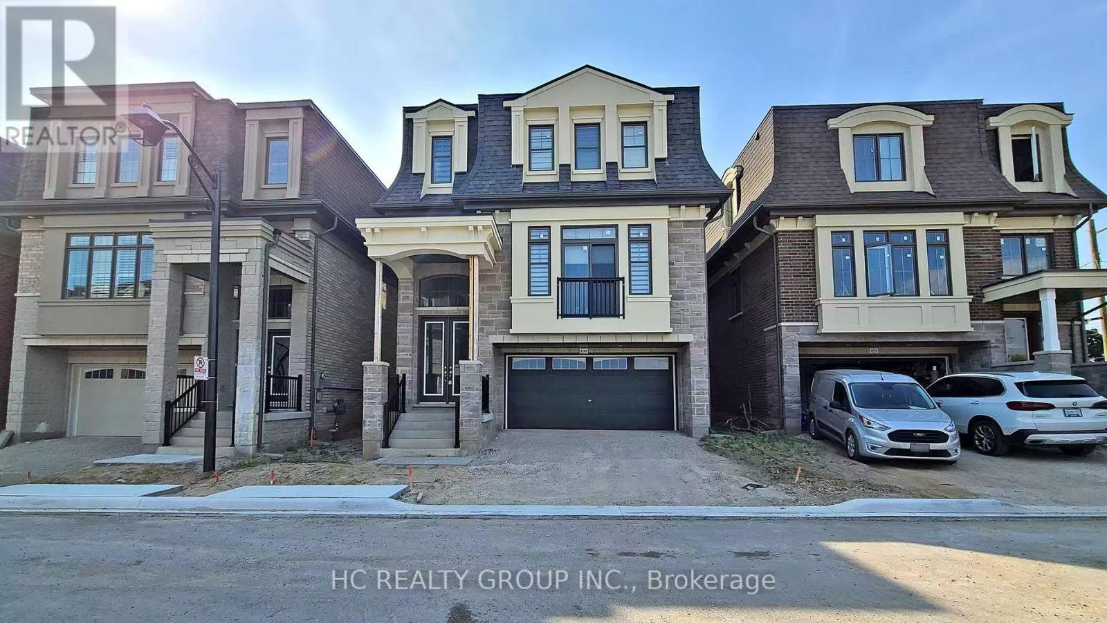 A row of houses with cars parked in front of them.