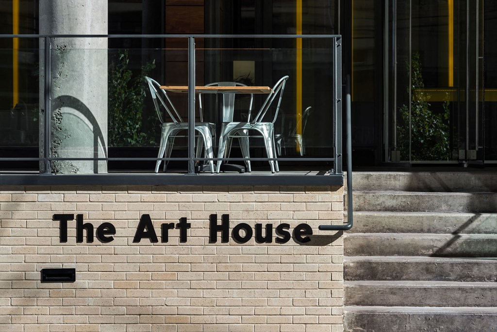 the art house signage on the side of a brick building