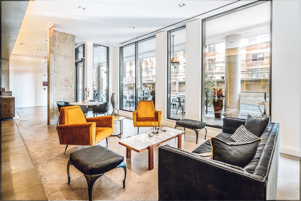 a living room with large windows and a couch and chairs