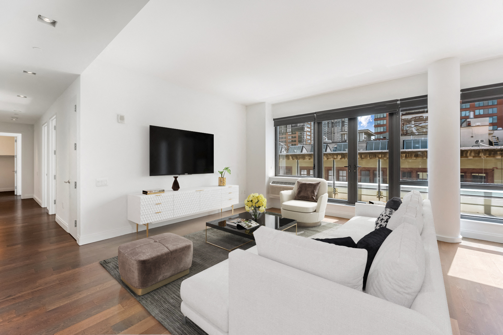 a living room with a white couch and a television