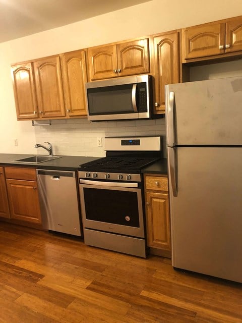 a kitchen with stainless steel appliances and wooden cabinets