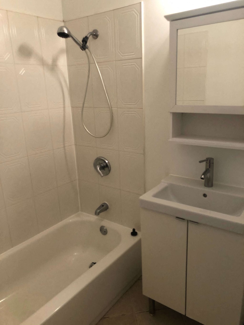 a white bathroom with a tub and a sink