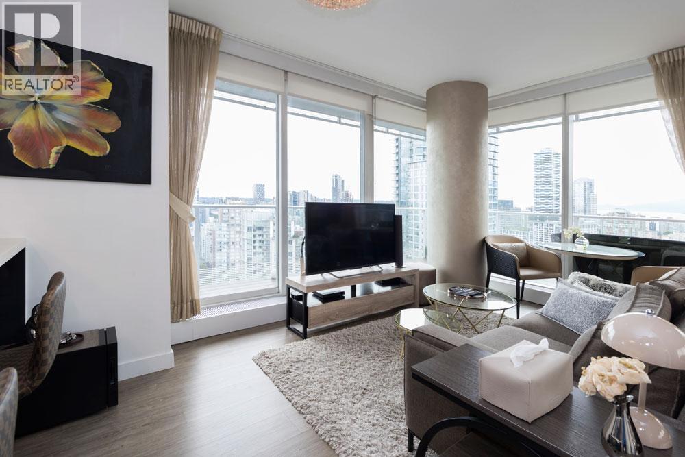A living room with a flat screen TV and a large window.