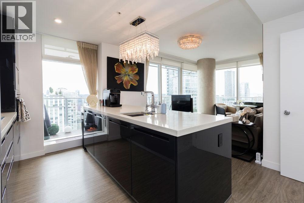 A modern kitchen with a large island and a view of the city.