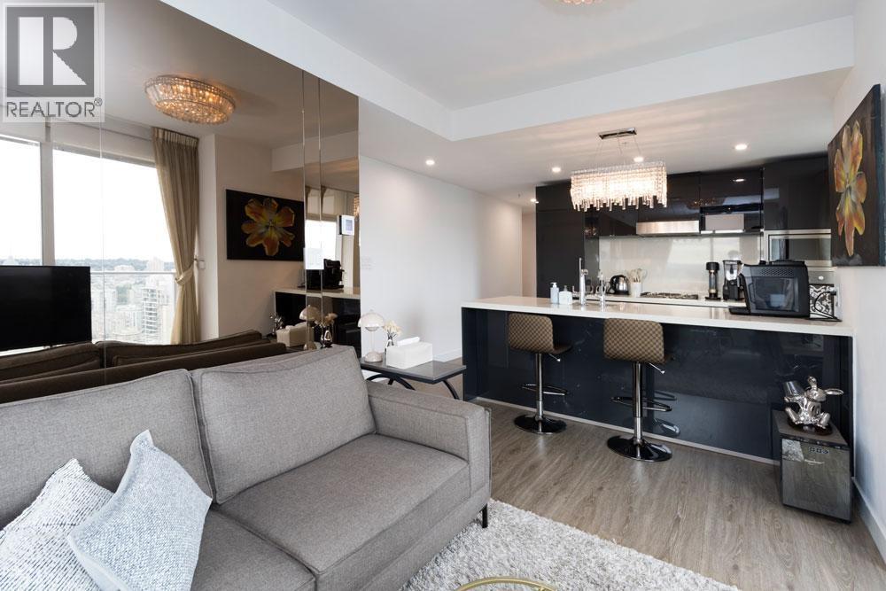 A modern living room with a grey sofa and a bar area.
