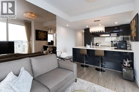 A modern living room with a grey sofa and a bar area.