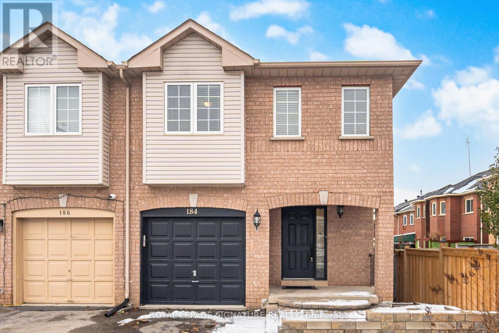 A two-story house with a black front door and a garage.