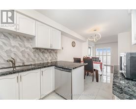 A kitchen with white cabinets and a black countertop.