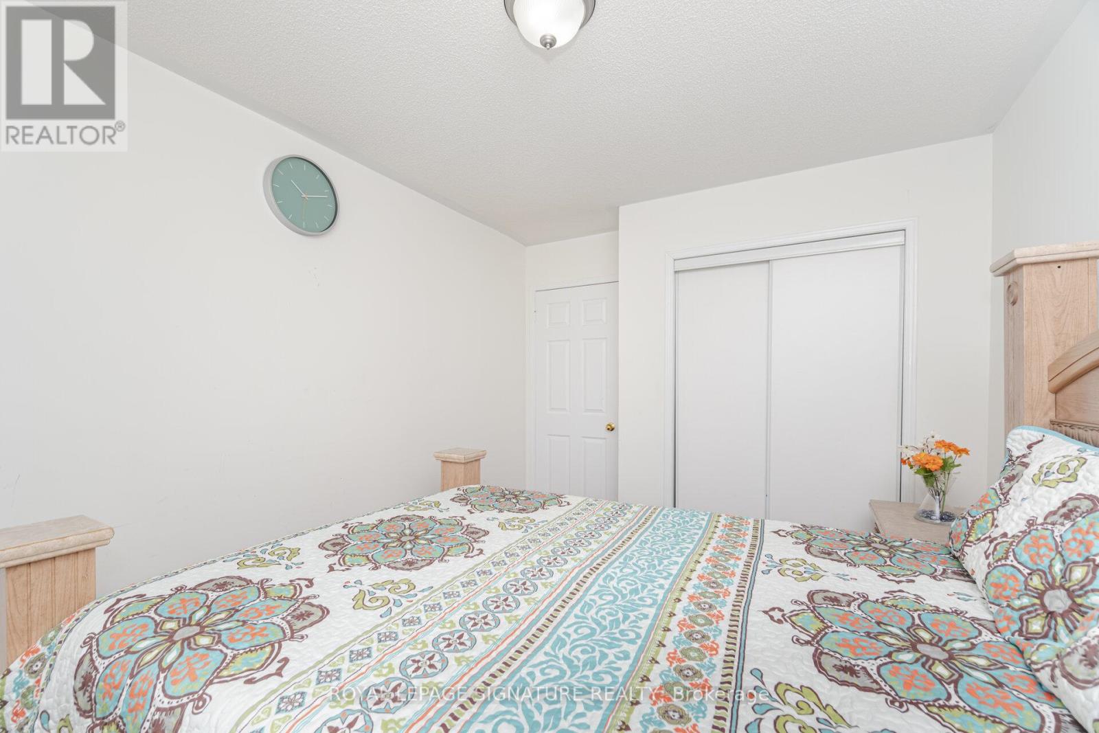 A bedroom with a large bed and a clock on the wall.