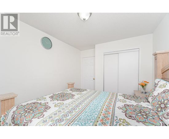A bedroom with a large bed and a clock on the wall.