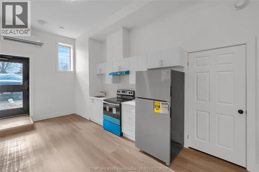 A kitchen with a refrigerator, stove, and cabinets.