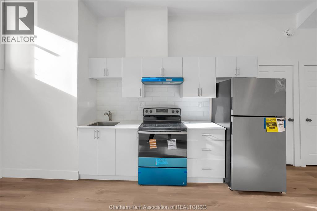 A kitchen with white cabinets and a blue dishwasher.