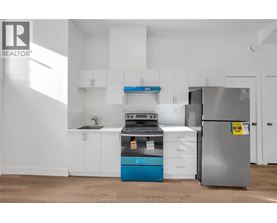 A kitchen with white cabinets and a blue dishwasher.