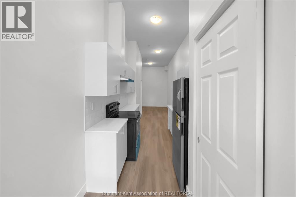 A hallway with a white door and a brown rug.