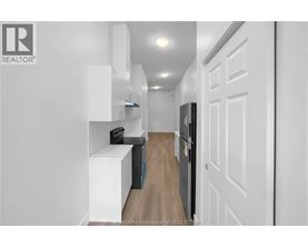 A hallway with a white door and a brown rug.