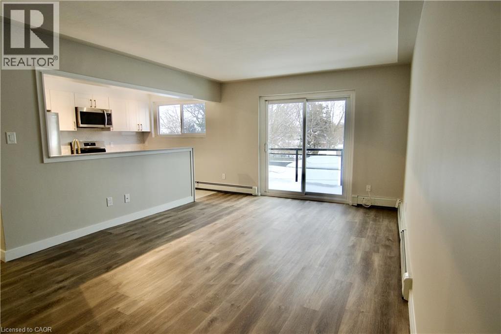 A spacious living room with wood flooring and a large window.