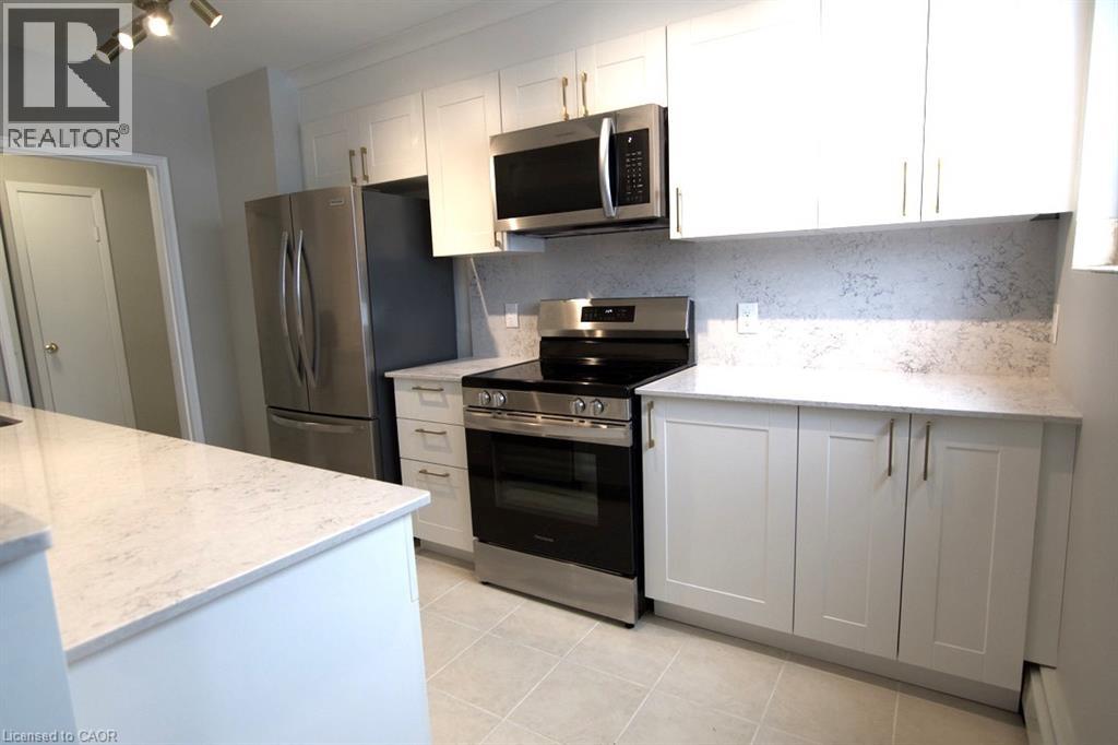 A kitchen with white cabinets and a marble countertop.