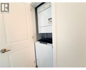 A white washing machine is in a small space between a door and a wall.