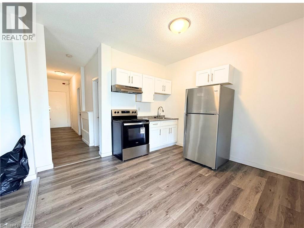 A kitchen with a refrigerator, oven, and microwave.
