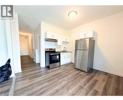 A kitchen with a refrigerator, oven, and microwave.