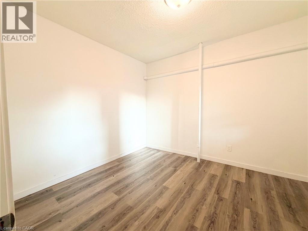 A room with wooden flooring and white walls.