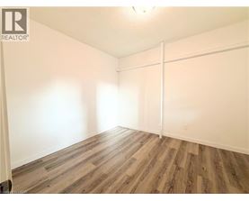 A room with wooden flooring and white walls.