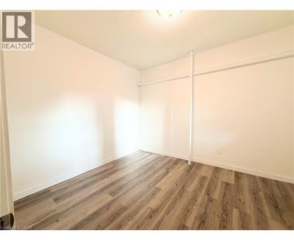 A room with wooden flooring and white walls.