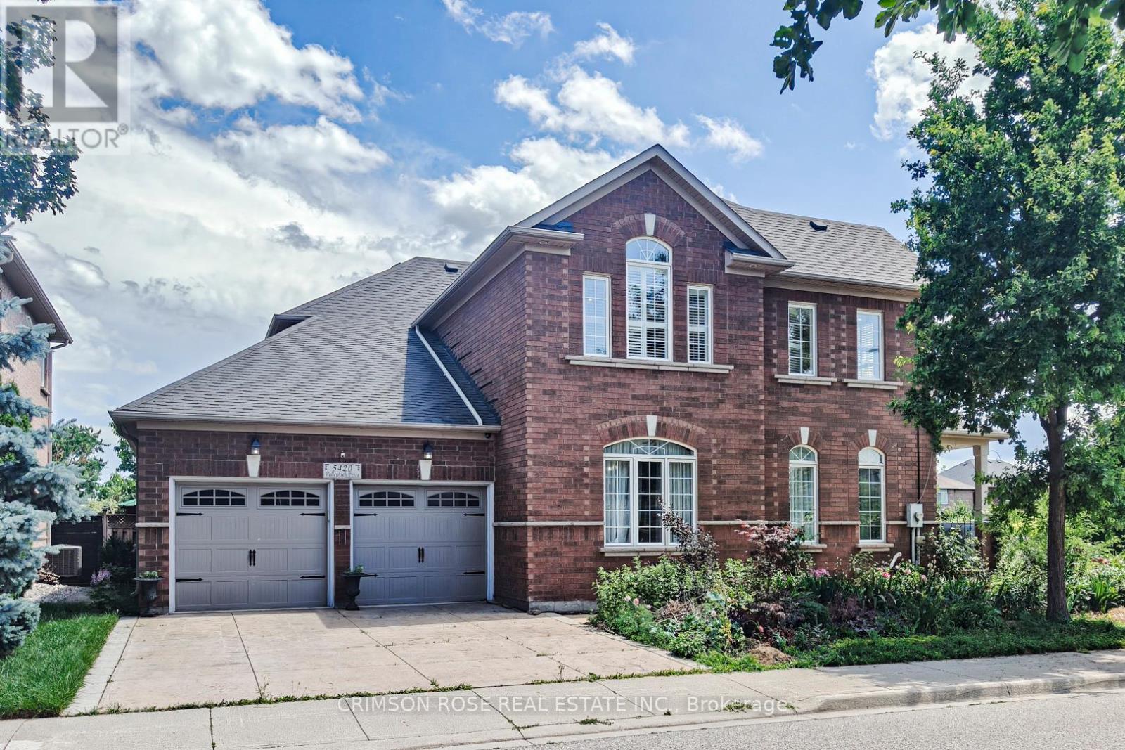 A brick house with a garage is for sale.