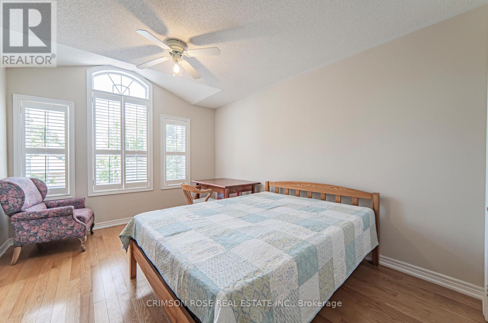 A bedroom with a bed, chair, and window.