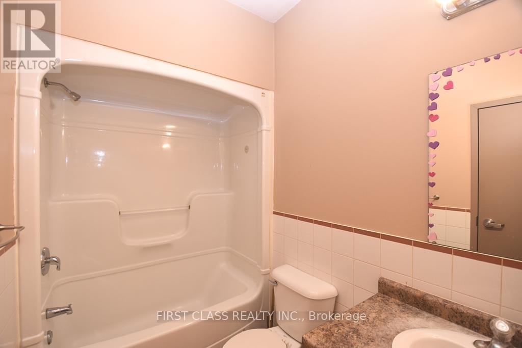 A bathroom with a tub, toilet, and sink.