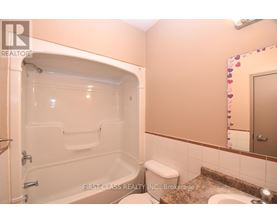 A bathroom with a tub, toilet, and sink.