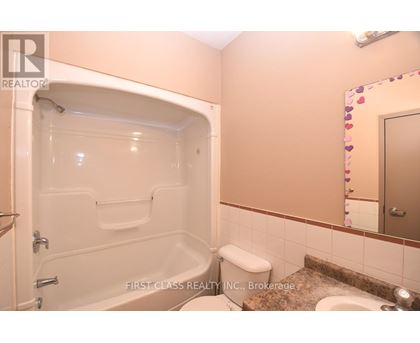 A bathroom with a tub, toilet, and sink.