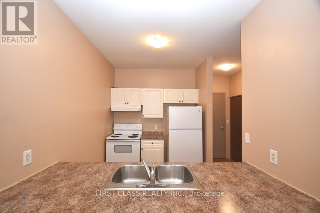 A kitchen with a sink and a refrigerator.