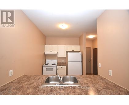 A kitchen with a sink and a refrigerator.
